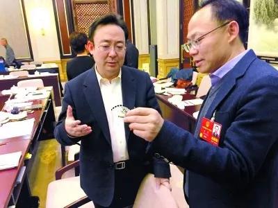 昨天,北京團(tuán)小組會(huì)休息的間隙,程京代表(右)向夏林茂代表介紹基因芯片。張宇攝
